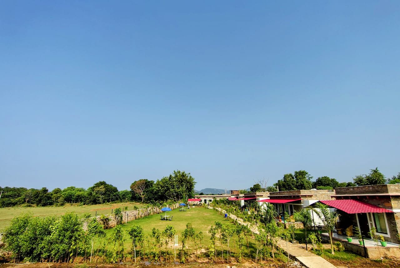 Row of Svaranya stone cottages with Aravalli hills beyond