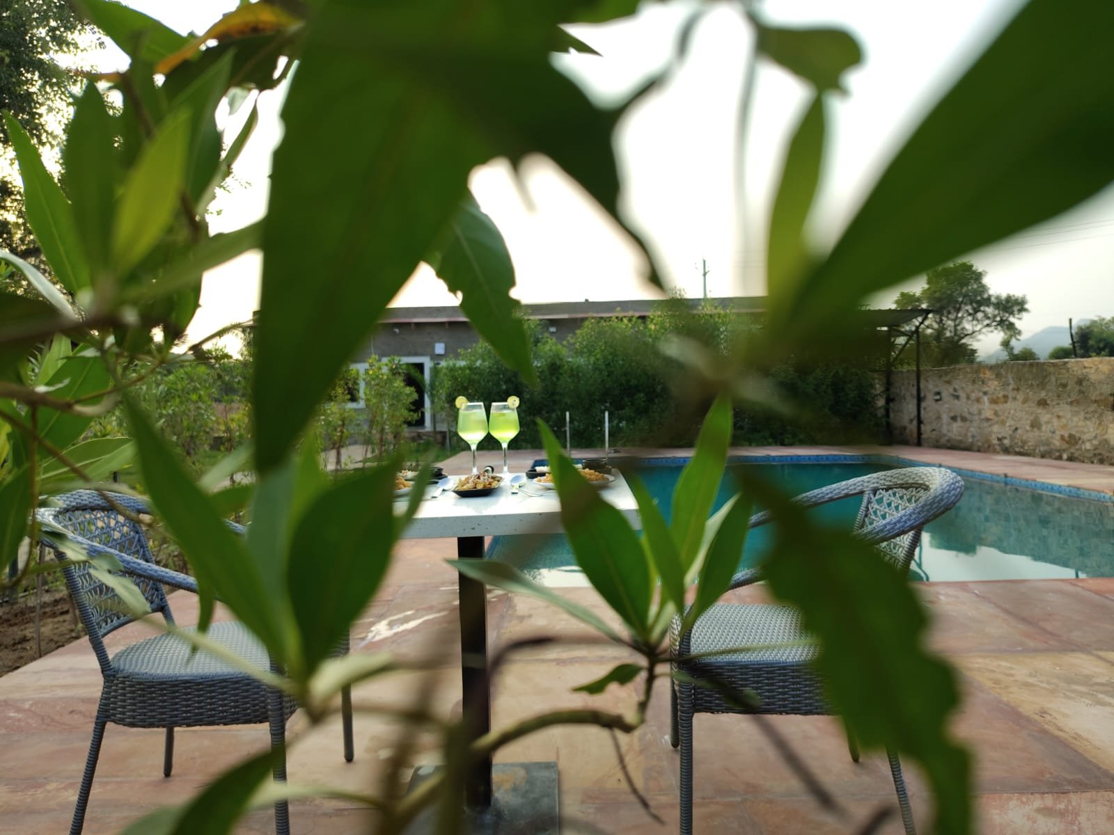 Poolside dining at Svaranya Resort framed by lush foliage
